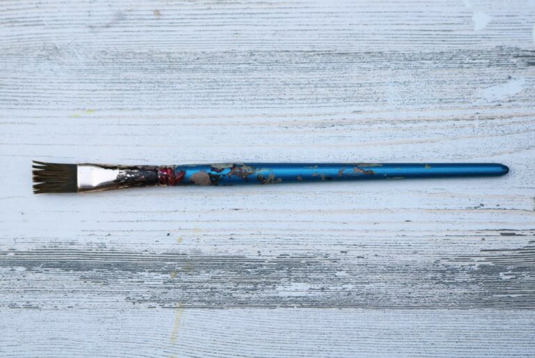 Old Worn Flat Paintbrush on Wood Background