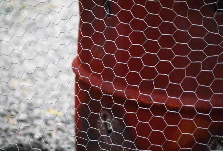 Chicken Wire Fence in Front of Rusted Burn Barrel