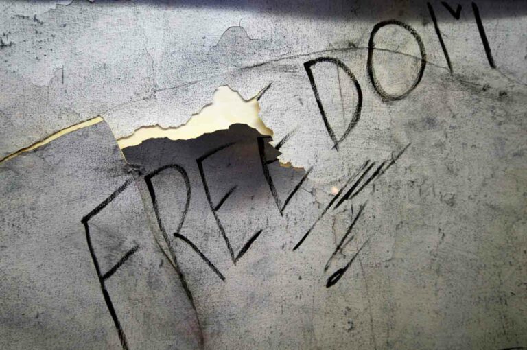 Graffiti of the Word Freedom on a Wall With Peeling Paint Stock Photo