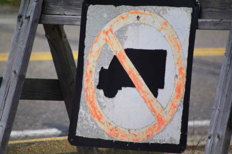 Distressed No Trucks Sign on a Wooden Horse Beside the Road Stock Photo