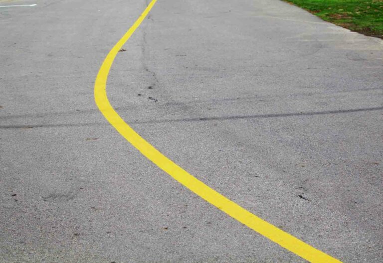 Stock Photo of a Curve in a Road with Yellow Do Not Cross Line
