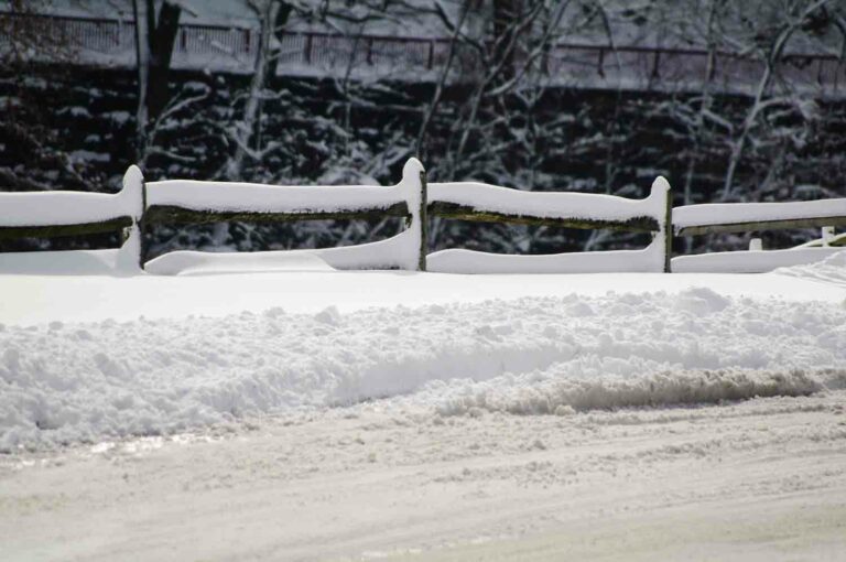 Snow Covered Fence Along Road